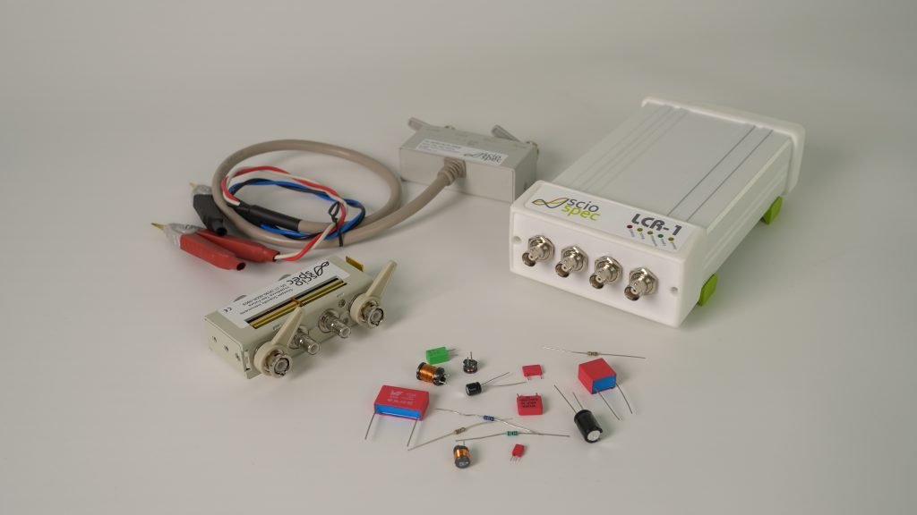 LCR-1 device connected to various electronic components including sensors, capacitors, resistors, and test fixtures.
